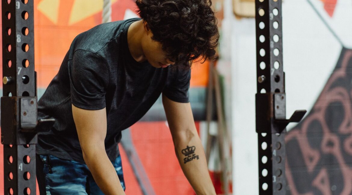 A certified personal trainer spotting a client during a barbell bench press for safety and proper form
